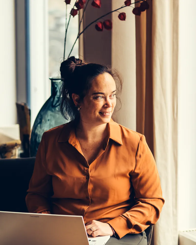 Molina van SjopSjop werkt bij het raam op haar laptop aan een WordPress website voor een ondernemer uit West-Friesland